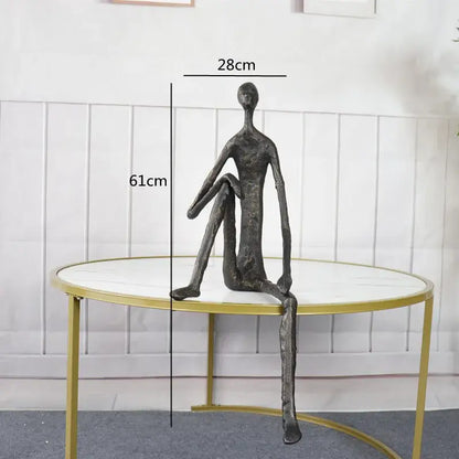 A sleek dark bronze abstract metal human sculpture with elongated limbs for living room decor by decorbites
