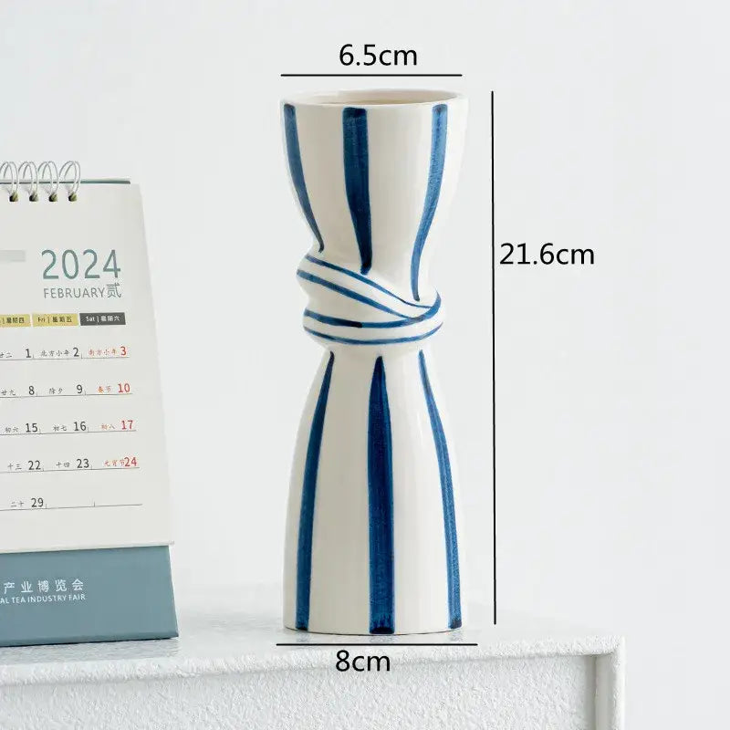 White ceramic hydroponic vase with bold blue vertical stripes and knotted design, abstract ceramic hydroponic style