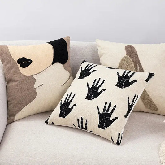 Cream-colored decorbites embroidered cotton cushion cover with black handprints and beige black abstract face design for living room decor