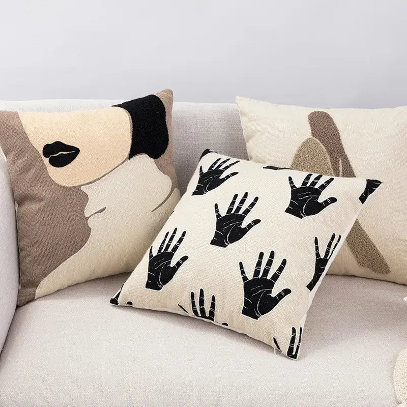 Cream-colored decorbites embroidered cotton cushion cover with black handprints and beige black abstract face design for living room decor