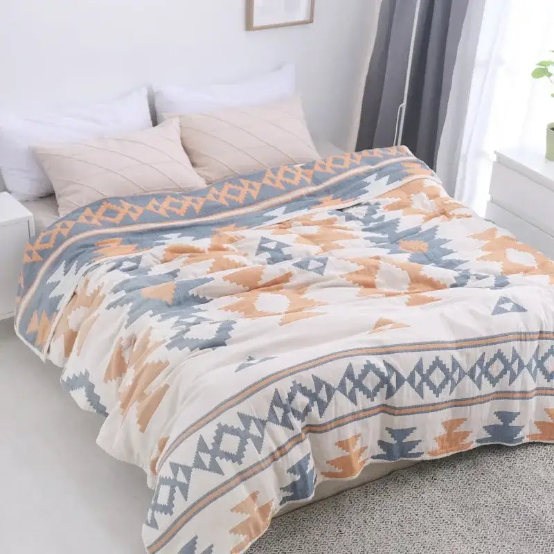 A cozy decorbites cotton nordic throw blanket in cream with blue and orange geometric tribal designs for bedroom decor