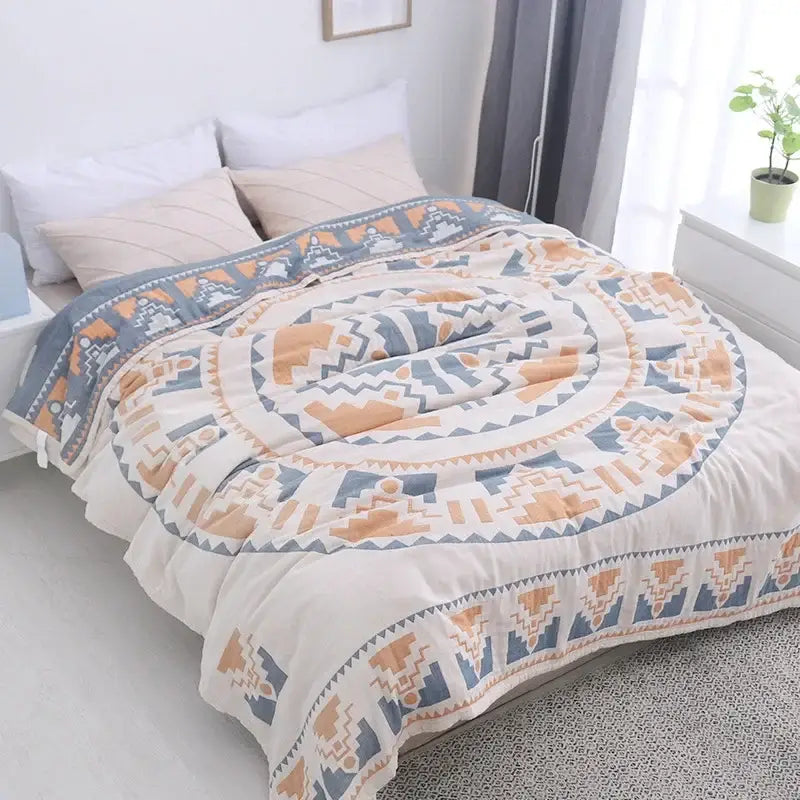 A cozy cream-colored cotton nordic throw blanket with bold blue and orange geometric concentric circles by decorbites