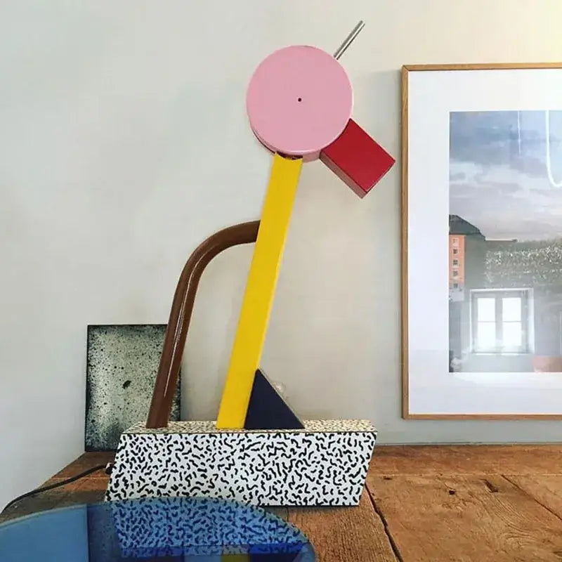 Abstract duck led table lamp with pink top yellow rod and geometric accents on speckled white base for bedroom use