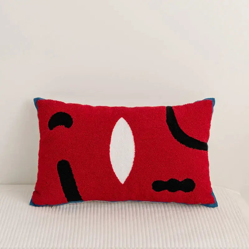 Red rectangular pillow cover with abstract black and white embroidery pattern bordered in blue for living room decor