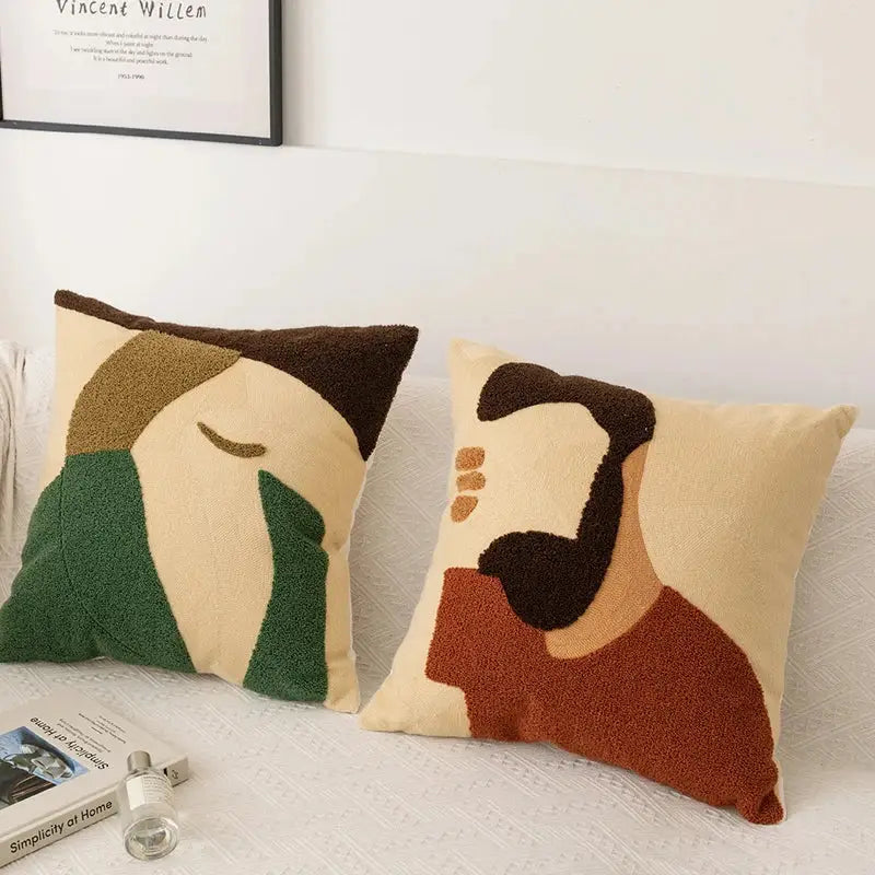 Two plush embroidery pillow covers with abstract pattern of male and female faces in earthy beige green brown and rust tones