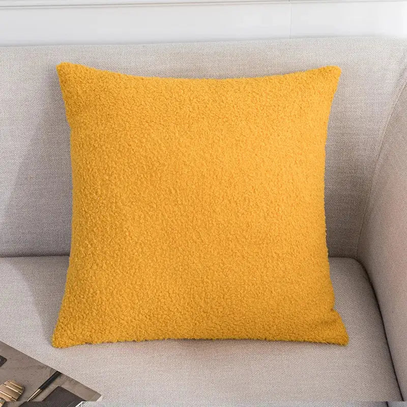 A cozy mustard-yellow fleece pillow on a gray couch complements decorbites abstract geometric pillow cover decor