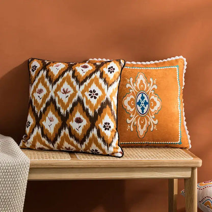 Two decorative throw pillows with orange and blue decorbites abstract geometric printed cushion cover on wooden bench