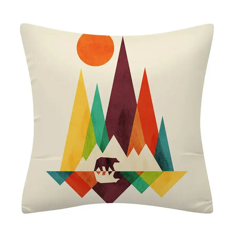Cream-colored cushion cover with decorbites geometry pattern featuring stylized mountain landscape and bear silhouette