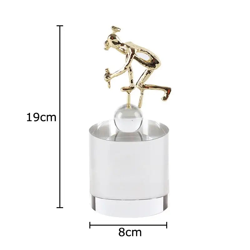 Gold-colored abstract figures desk cyclist figurine atop decorbites crystal sculpture clear cylindrical base