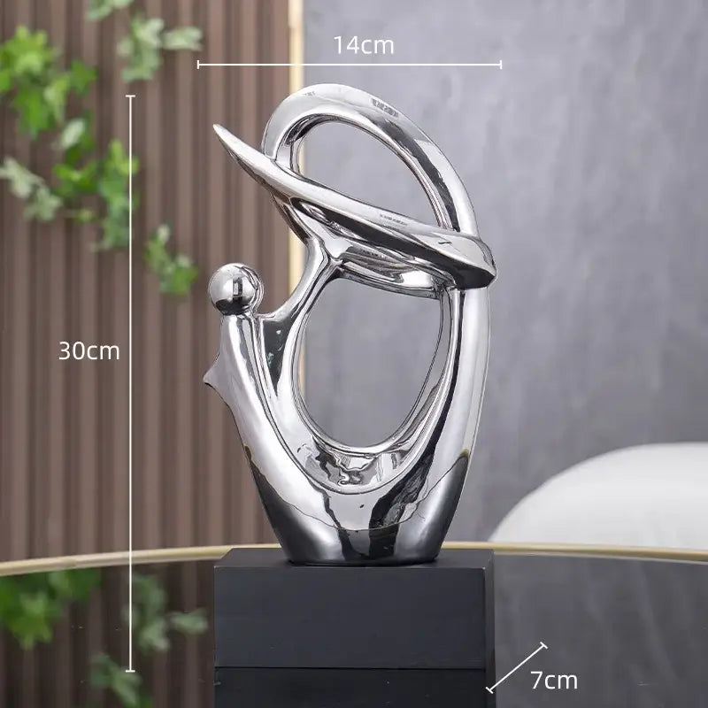 Shiny silver abstract decorative figurine with flowing forms and spherical base element for living room decorbites golden geometric style