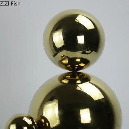 Shiny gold metallic abstract golden balls geometric sculpture composed of three stacked spheres for living room decor