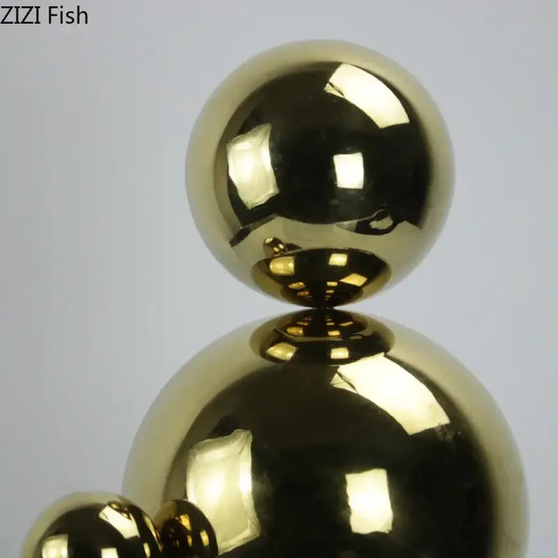 Shiny gold metallic abstract golden balls geometric sculpture composed of three stacked spheres for living room decor