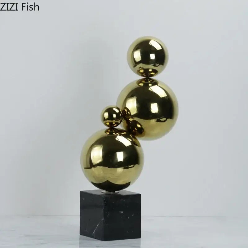 Abstract golden balls geometric metal sculpture with shiny gold metallic spheres stacked on black marble base for living room decor