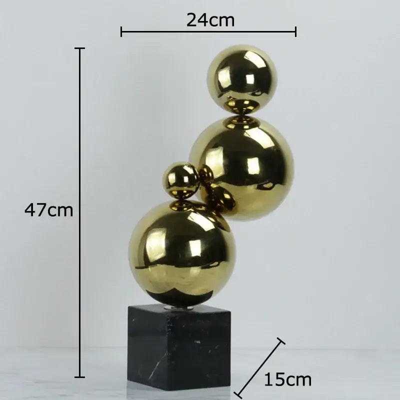 Abstract golden balls geometric metal sculpture featuring cascading golden spheres on black marble base for living room decorbites golden balls