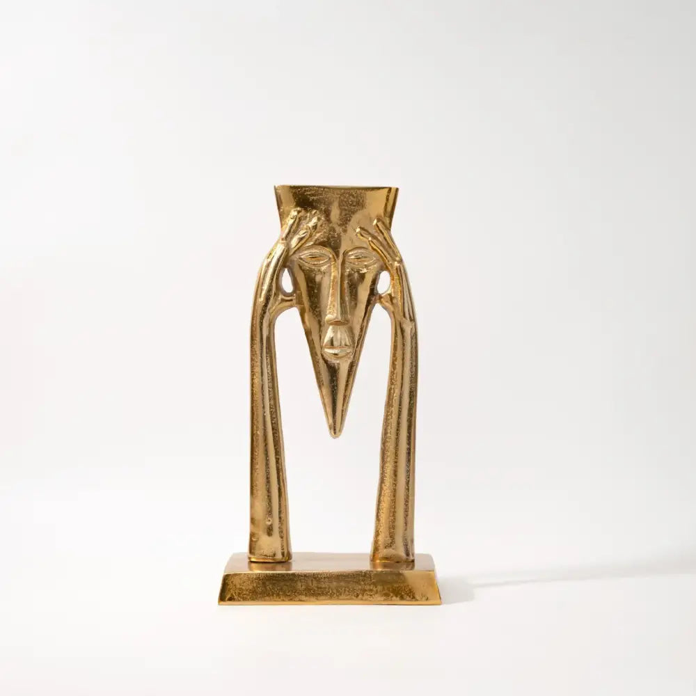 Golden metallic abstract golden masked figure sculpture with elongated features and slender arms for living room decor