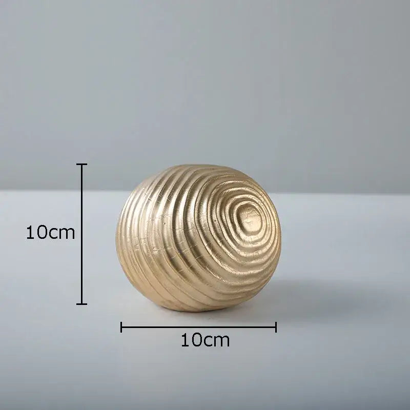 A 10cm diameter golden wave ball sculpture with concentric textured ridges for living room metal decor