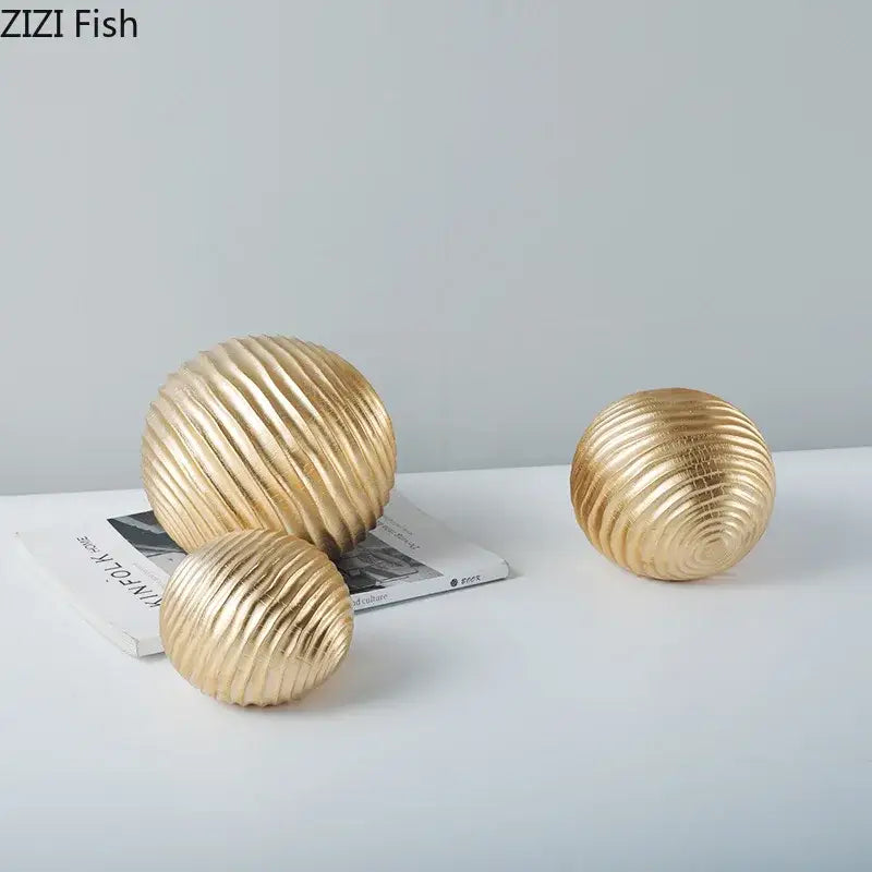 Gold-colored ribbed metal decorative golden wave ball sculpture with a glossy finish for living room decor