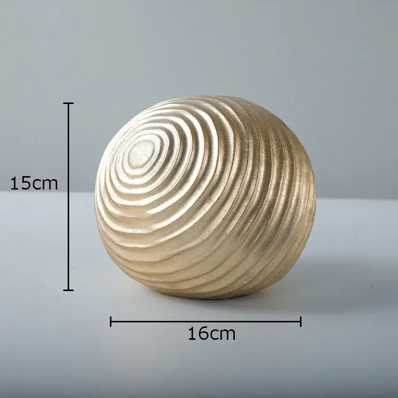 A 15cm tall golden wave ball sculpture with concentric ridged metal patterns for living room decor