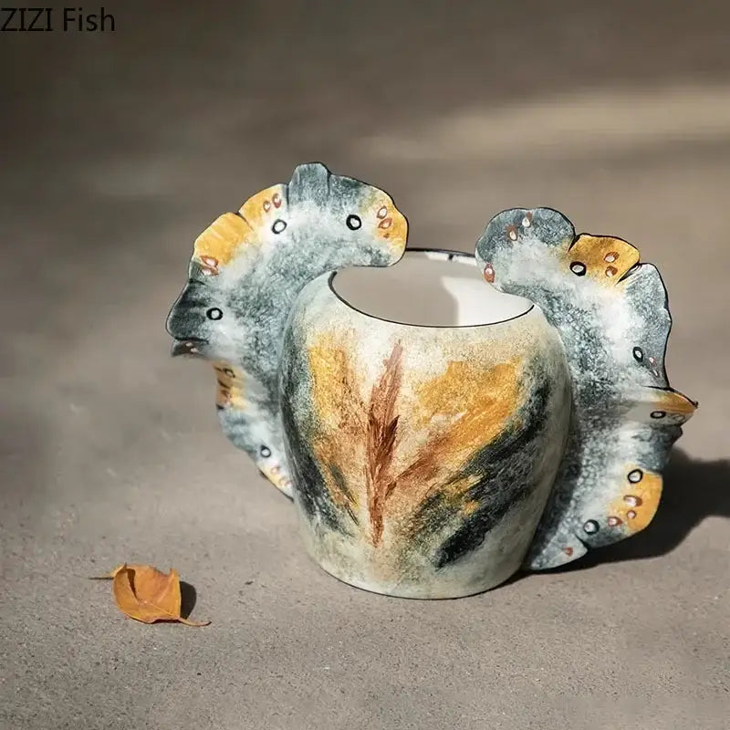 Hand-painted ceramic butterfly wings vase with leaf-shaped handles and feather motif in gray and orange tones for bedroom decor