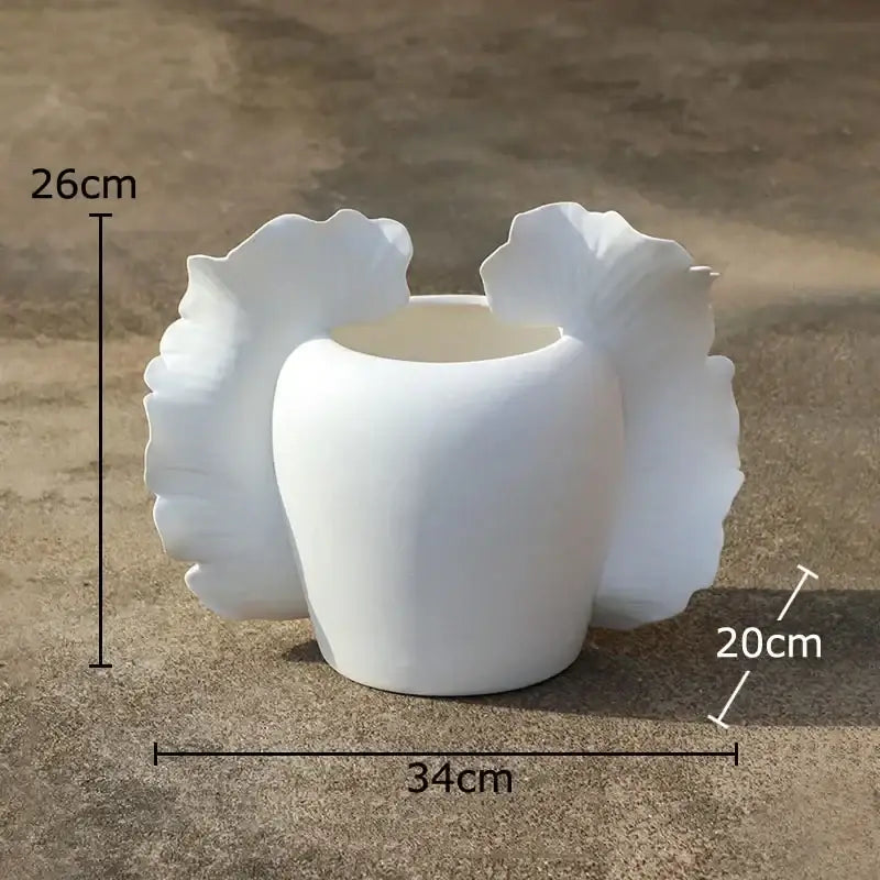 White ceramic butterfly wings vase with sculpted leaf-like flares for abstract gray and orange bedroom decor