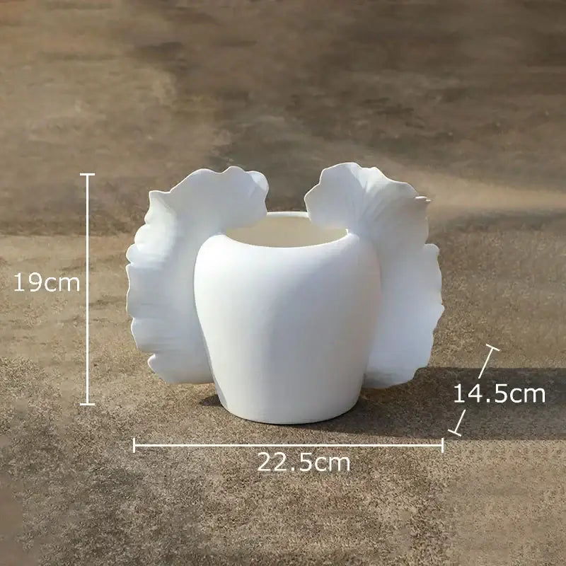 White ceramic wings vase with sculpted leaf-like flares inspired by abstract gray and orange butterfly wings decor