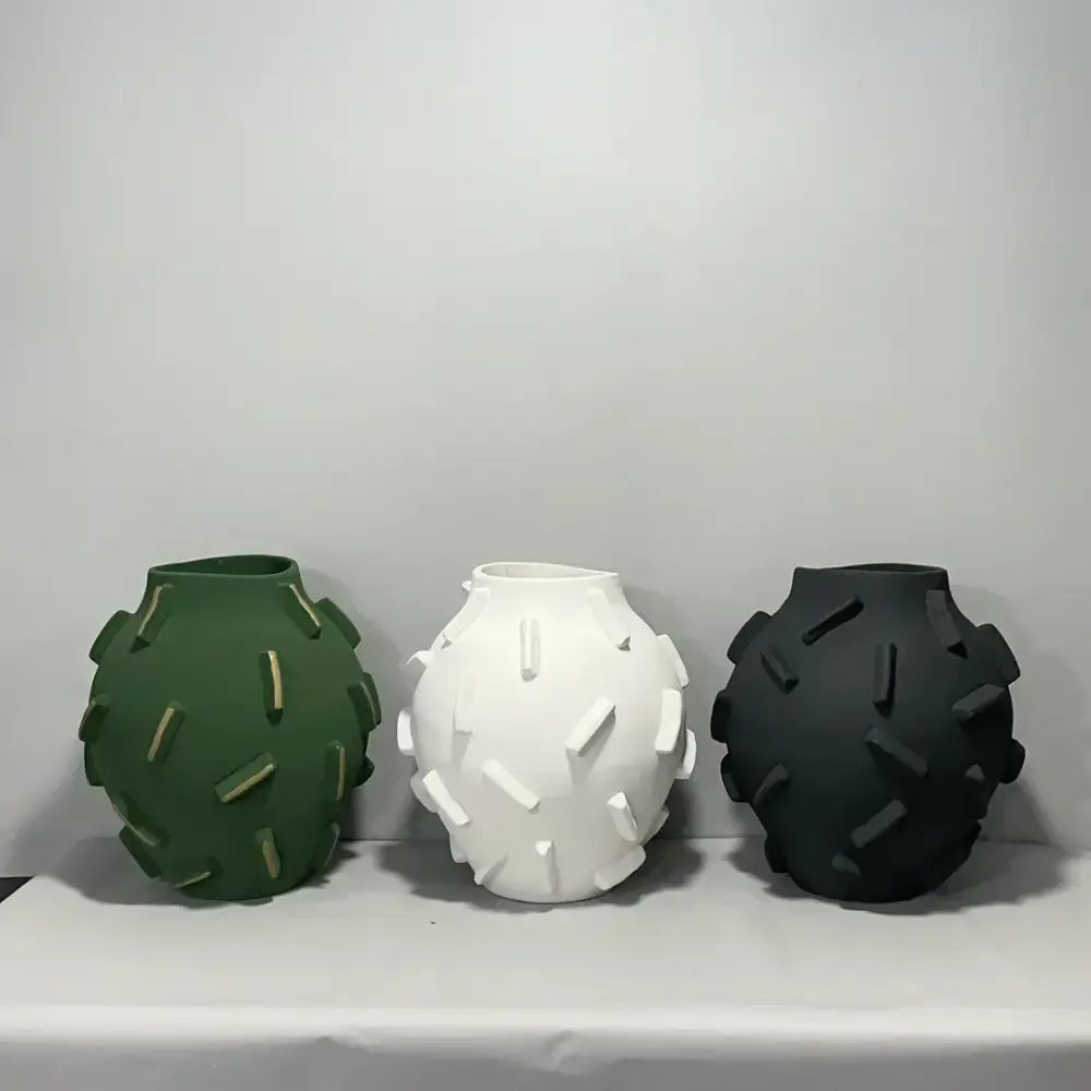 Three ceramic geometric block vases in green white and black with textured raised rectangular decorbites geometric block surface