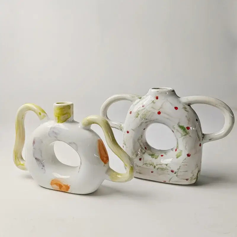 Two ceramic abstract handle ceramic vases with yellow accents and red dots for green and red living room decor