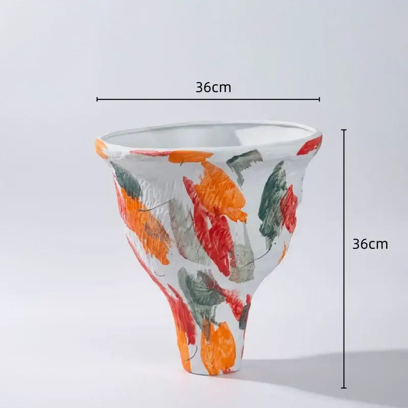 A 36cm tall abstract irregular ceramic vase set with flared shape and bold orange red green brushstrokes on white base decorbites