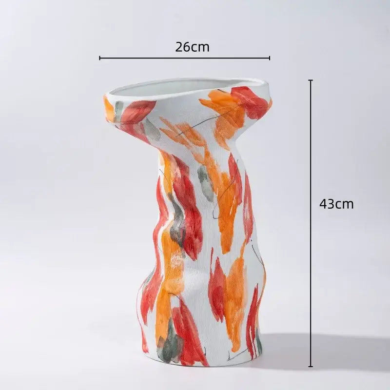 A tall slender white ceramic vase with abstract irregular orange red leaf patterns in a decorbites vase set