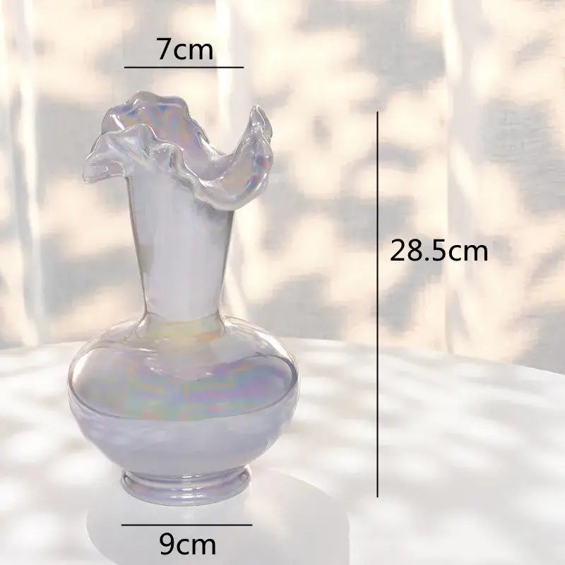 A translucent iridescent glass vase with a fluted ruffled rim and rounded base for decorbites ceramic shell decor