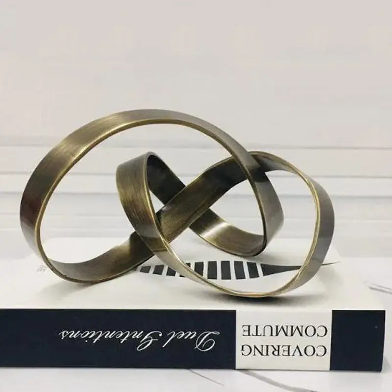 Bronze-colored metal abstract knot sculpture with interlocking circular bands for living room decorbites abstract knot decor