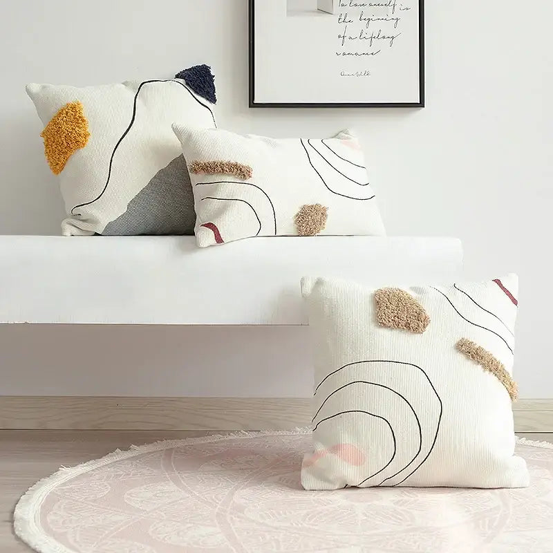 White textured cushion cover with abstract line colors and beige yellow pink felt accents for living room decorbites