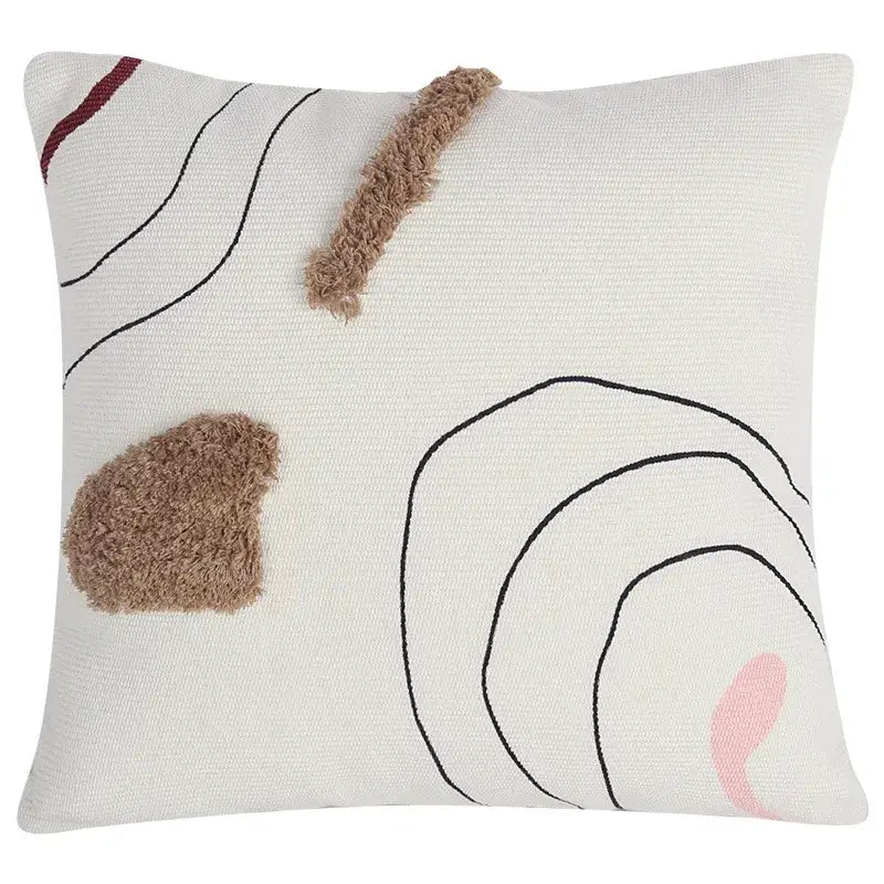 Cream-colored cushion cover with decorbites abstract line design featuring black curves pink accent and brown tufted patches