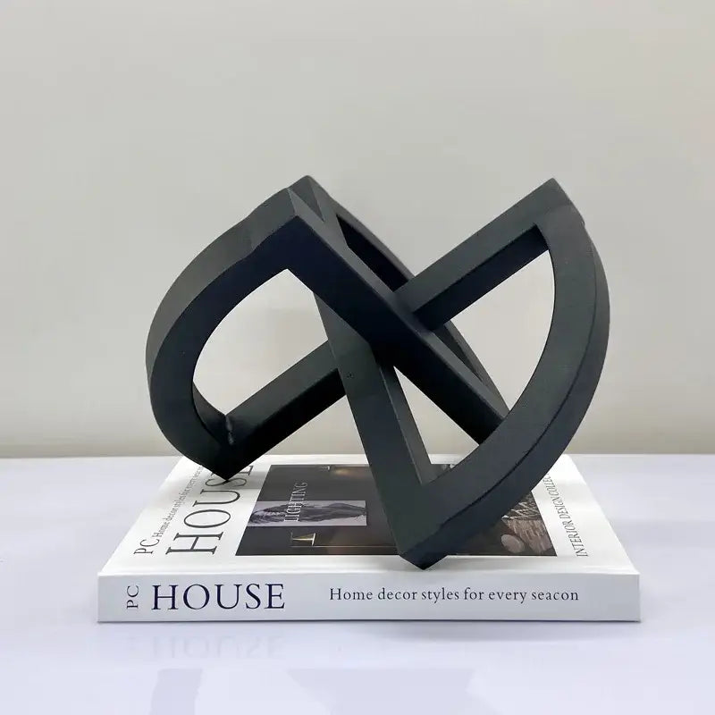 Black matte-finished abstract geometric sculpture with interlocking loops as an ornament abstract home decoration