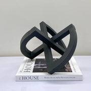 Black matte-finished abstract geometric sculpture with interlocking loops for abstract home decoration living room