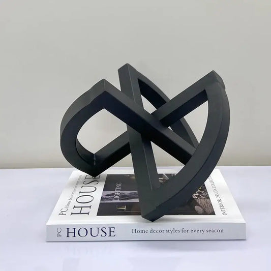 Black matte-finished abstract geometric sculpture with interlocking loops for abstract home decoration living room