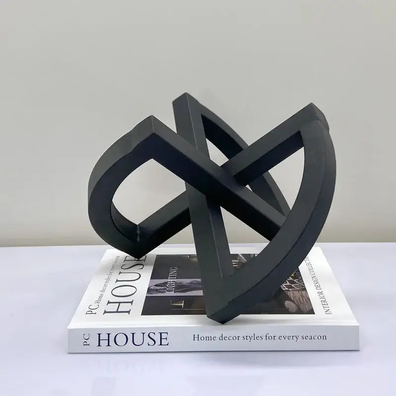 Black matte-finished abstract geometric sculpture with interlocking loops for abstract home decoration living room