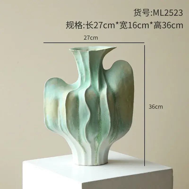 Abstract mint and olive ceramic vase with irregular folds in flowing organic curves for living room decor