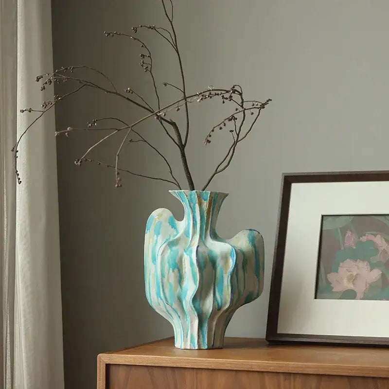 Abstract mint and olive ceramic vase with irregular folds and flowing turquoise and white marbled patterns for living room