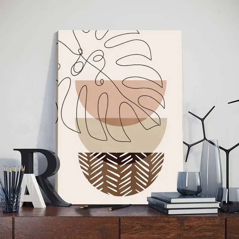 Minimalist canvas leaf posters featuring abstract orange leaf designs with black line monstera outlines on beige brown shapes