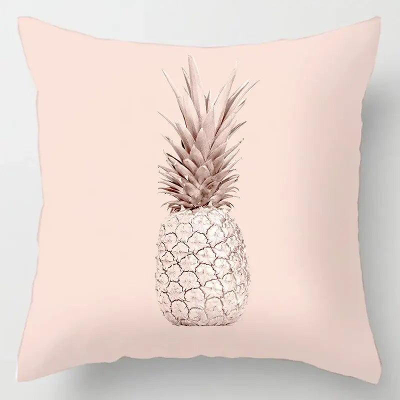 A soft pink cushion cover with a stylized pineapple and geometric leaves print in muted silver and beige tones