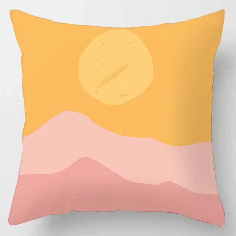 A square cushion cover with geometric leaves print featuring a minimalist pink mountain sunset and yellow sun design