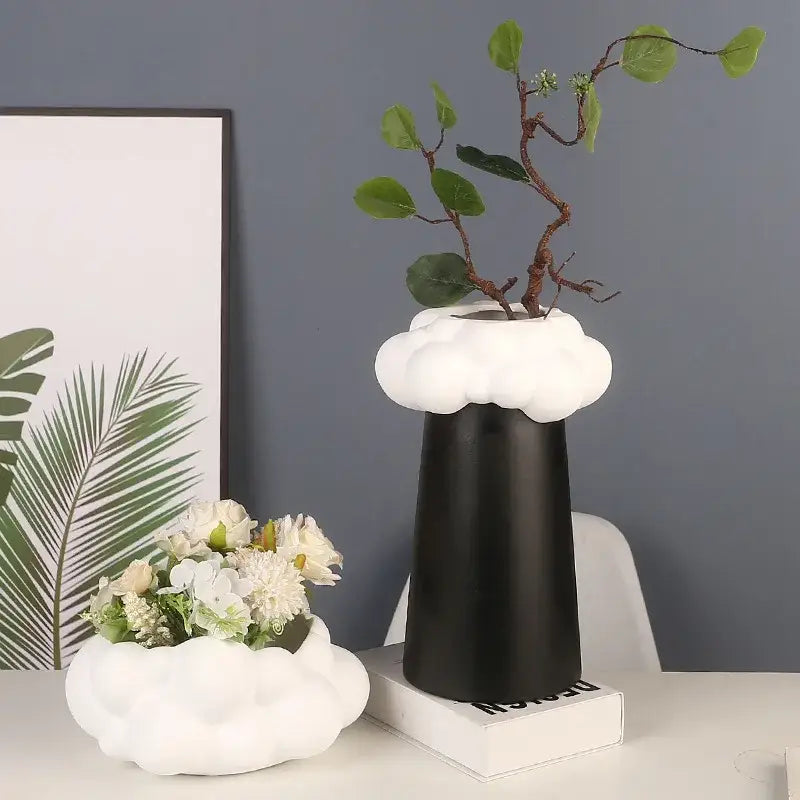 Black abstract patchwork ceramic vase with white cloud-shaped top holding greenery for living room decor