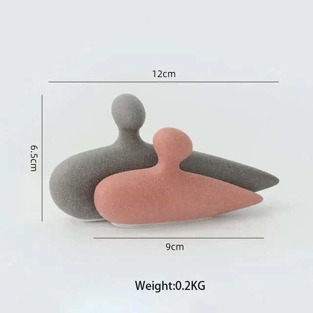 Two minimalist ceramic art couple statue figurines in matte gray and soft pink with speckled texture for living room decor