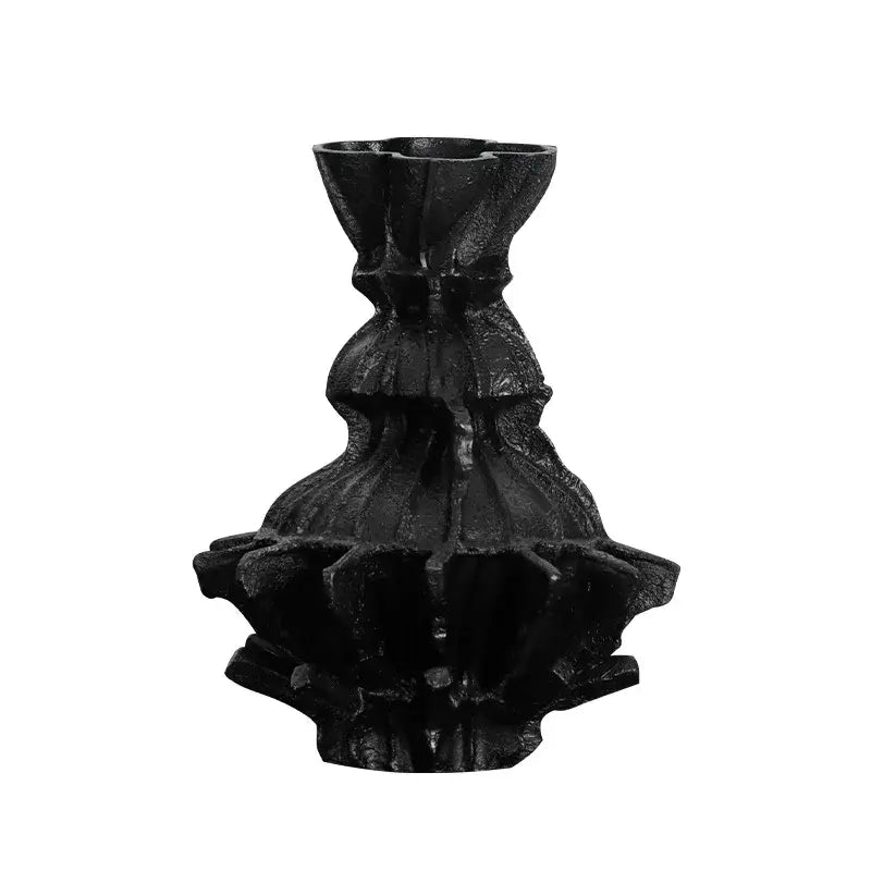 Black cast iron candle holder with tiered fluted design resembling abstract pleated gear for living room decor