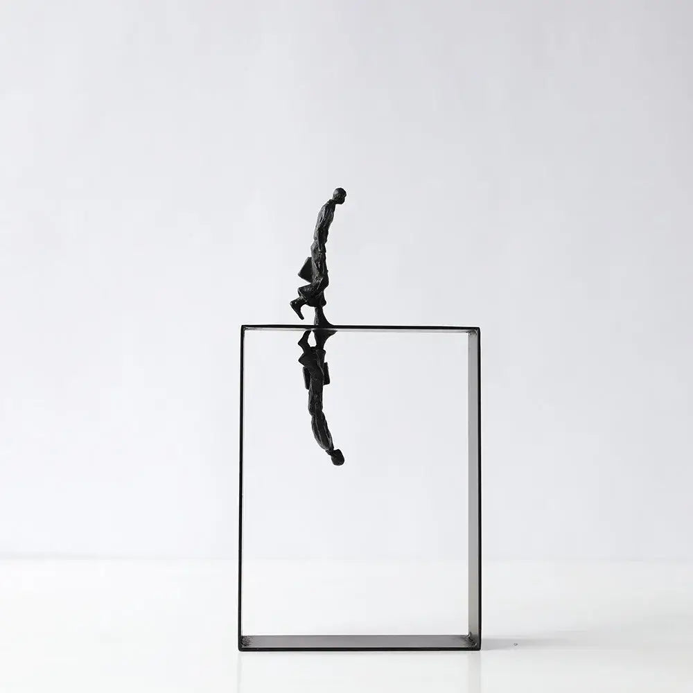 Black metallic resin sculpture of a man balancing on the edge of a transparent glass cube for living room decorbites abstract resin decor