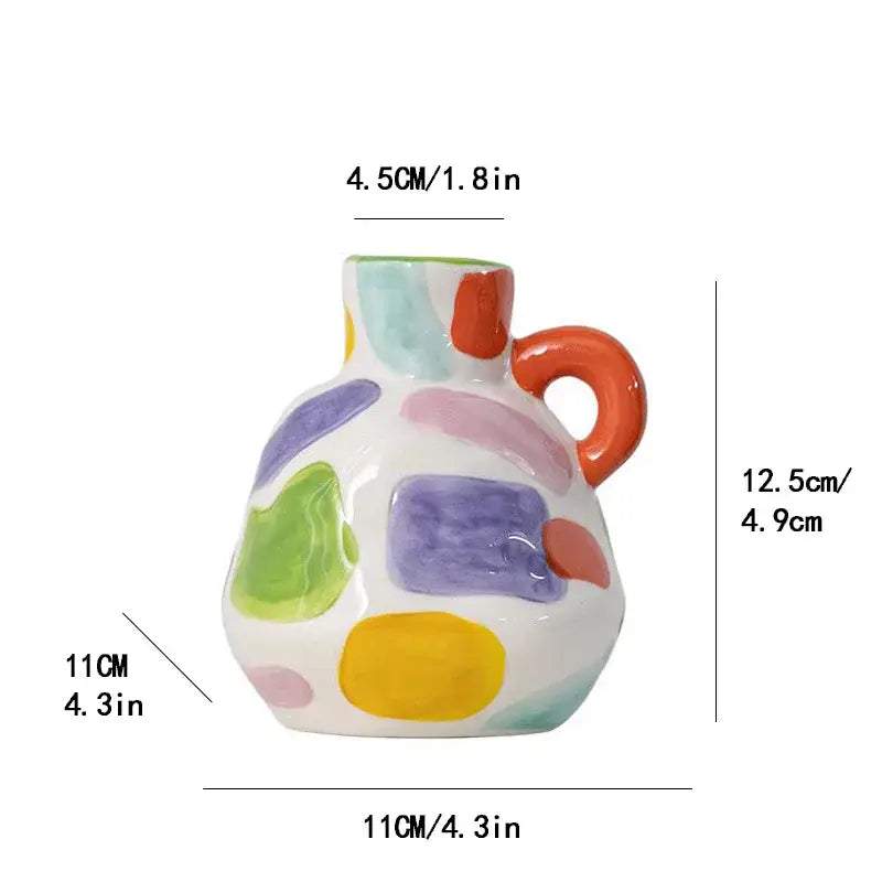 A white ceramic vase teapot with orange handle and colorful abstract patches for decorbites cartoon ceramic decor