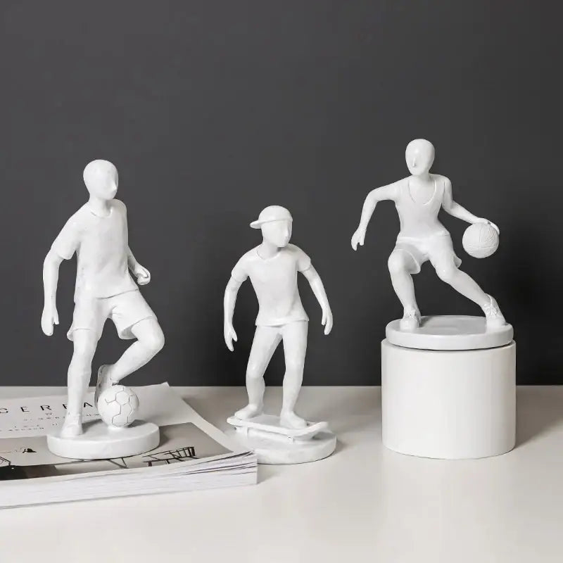 Three white resin abstract sports player sculptures depicting soccer skateboarding and basketball for living room decorbites decor