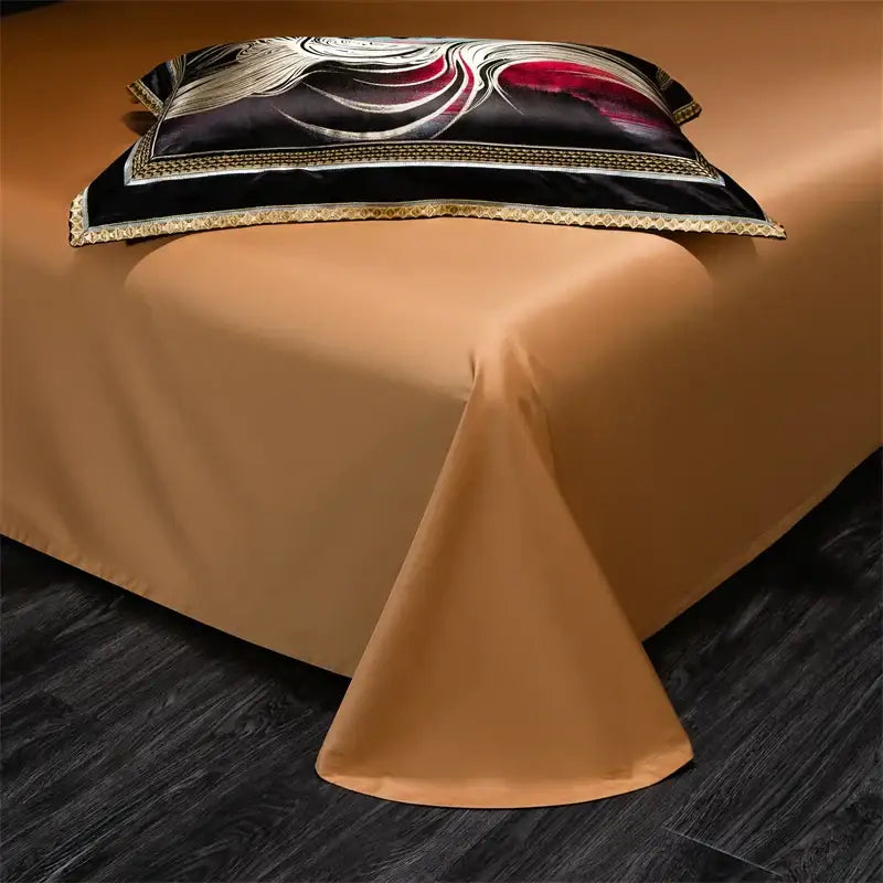 A black satin pillow sham with gold and red wave embroidery and golden trim from an abstract wave duvet cover set