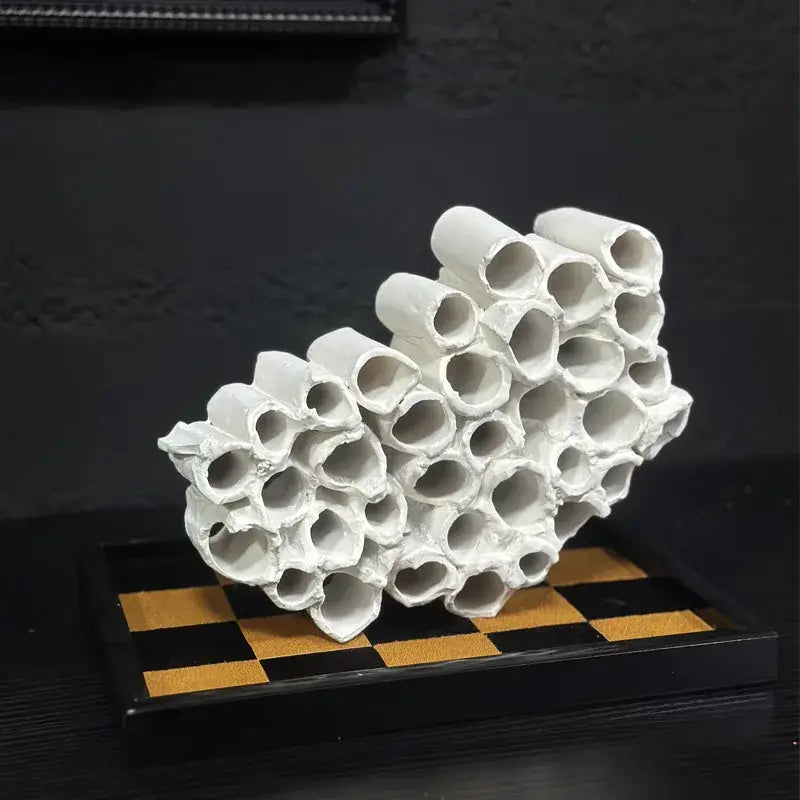 White ceramic abstract sculpture featuring interconnected honeycomb mesh conduit tubes for living room decor